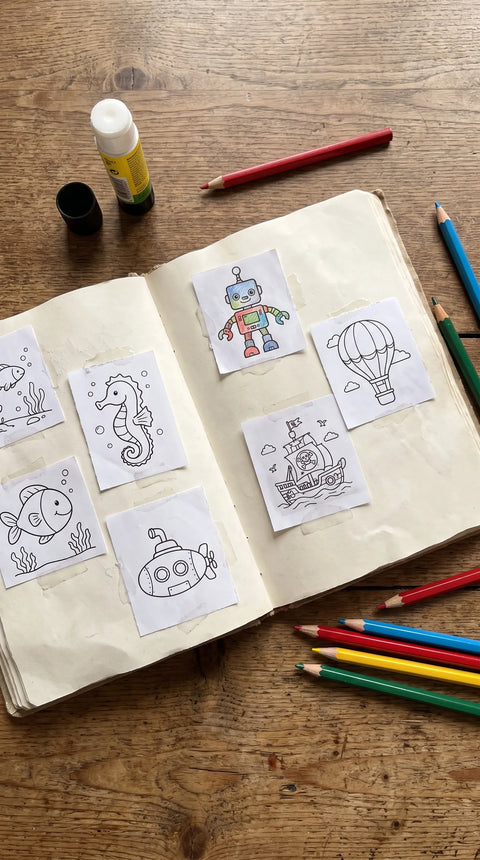 Ein aufgeschlagenes Heft mit kleinen Tier-, Roboter- und Abenteuerzeichnungen liegt zwischen Buntstiften.